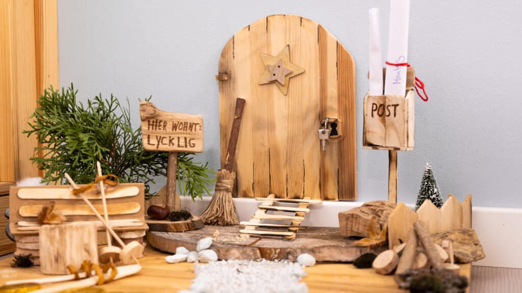 Kleine Holztür mit Briefkasten und mehr an der Wand von einem Weihnachtswichtel