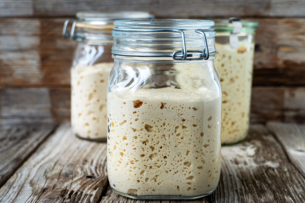 Drei Gläser Sauerteiganstellgut auf Holz