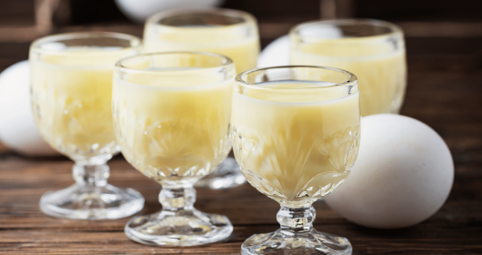 Eierlikör mit Eiern auf Holztisch