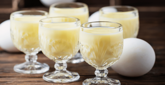 Eierlikör mit Eiern auf Holztisch