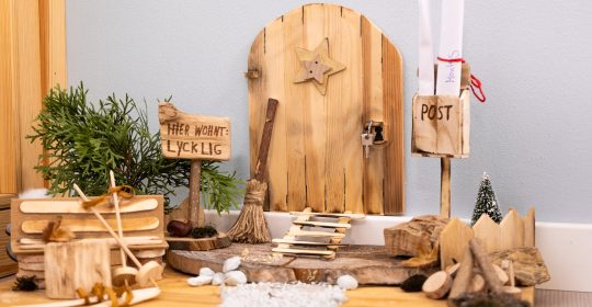 Kleine Holztür mit Briefkasten und mehr an der Wand von einem Weihnachtswichtel