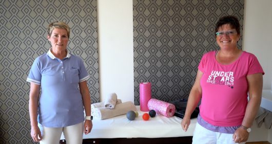 Zwei Physiotherapeutinnen vor einer Liege mit Handtüchern und Faszienrollen