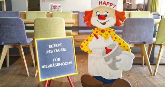 Holzaufsteller eines Clowns als Koch im Restaurant