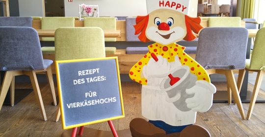 Holzaufsteller eines Clowns als Koch im Restaurant