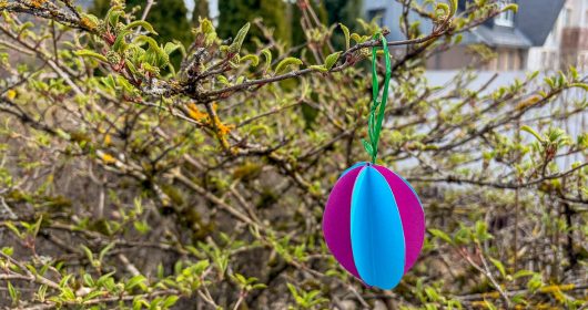 Buntes Papierosterei an einem Baum hängend