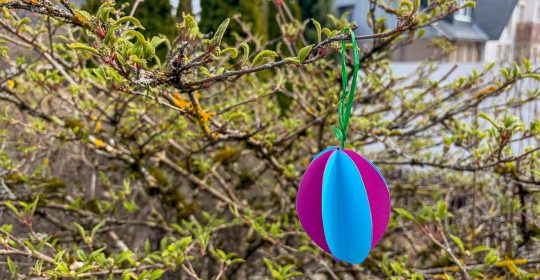 Buntes Papierosterei an einem Baum hängend