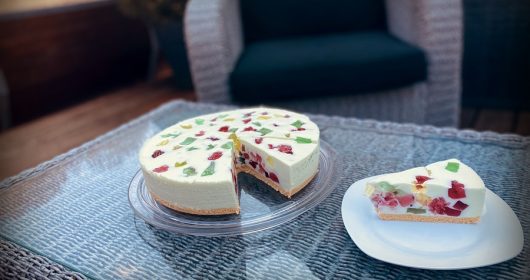 Philadelphiatorte auf einem Glasteller auf Terrassenmöbel