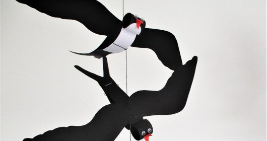 Bastelarbeit als schwarze Schwalbe an einer Schnur aus Tonkarton