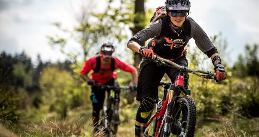 Mann und Frau auf Mountainbikes fahren durch den Wald