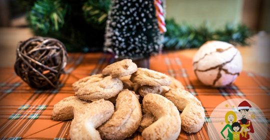 Vanillekipferl auf einer Serviette umgeben von Weihnachtsdekoration