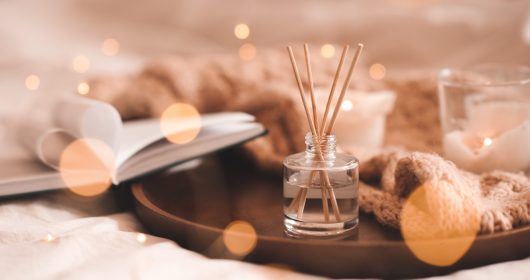 Winterliche Aromatherapie mit Duftstäbchen auf Tablett mit Buch