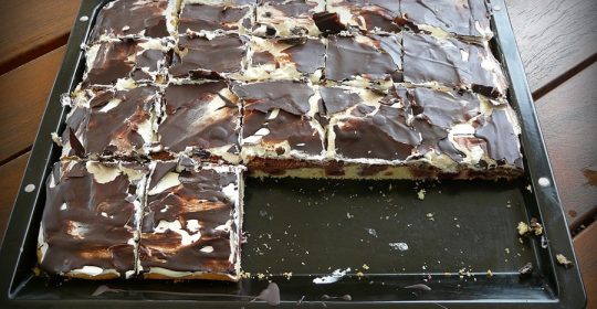Backblech mit Donau-Welle-Kuchen auf einem dunklen Holztisch