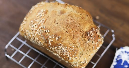 Dinkelbrot auf einem Backrost auf Holztisch