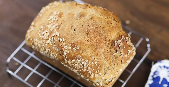 Dinkelbrot auf einem Backrost auf Holztisch