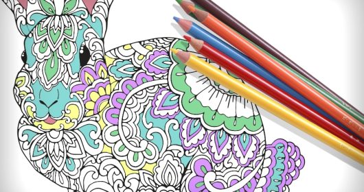 Mandala-Hase und Buntstifte auf weißem Papier