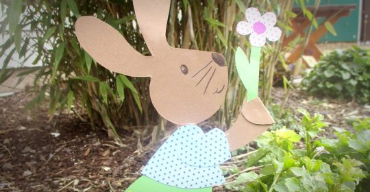 Hase aus Tonkarten vor einem Strauch