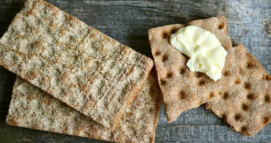 Mehrere Scheiben Knäckebrot, teilweise mit Butter bestrichen