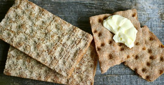 Mehrere Scheiben Knäckebrot, teilweise mit Butter bestrichen
