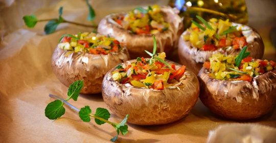 Mit Paprika gefüllte Champignons auf Backpapier