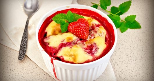 Quark Grieß Auflauf mit Erdbeere in einer weißen Schüssel, garniert mit Minze