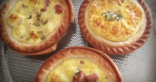 drei überbackene Mini-Quiches auf einem Blech