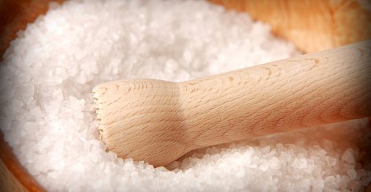 Salz in einer Holzschale mit Holzstößel