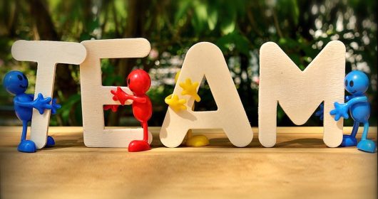 bunte Holzfiguren halten das Wort "Team"